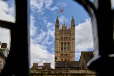 View of the Victoria Tower framed through a window with Union Jack flag