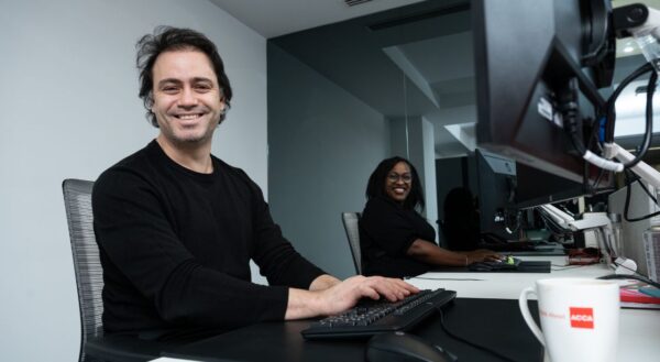 ACCA employees sitting at a desk smiling