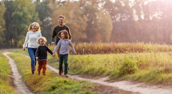 A mum, dad and their two kids happily exploring nature