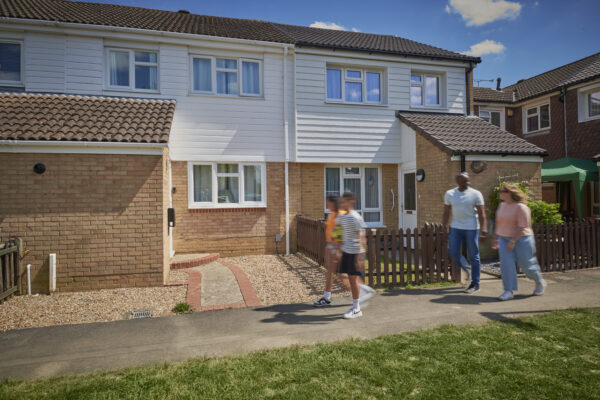 Family walking past houses in Crawley