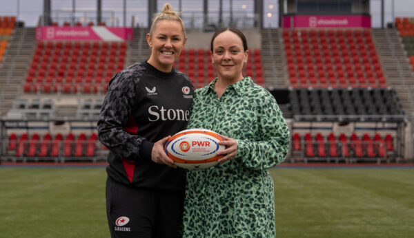 Marlie Packer & Kerry Appleyard holding a rugby ball on a pitch