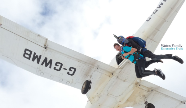 Robin Kinnard undertaking a parachute jump to raise money for Papyrus with WFET logo