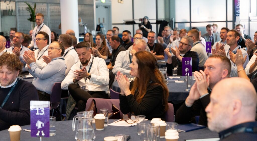 tables image with attendees clapping and smiling